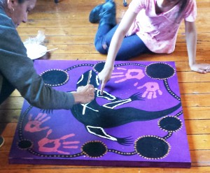 Daisy and Nyoka working together on their Goanna painting